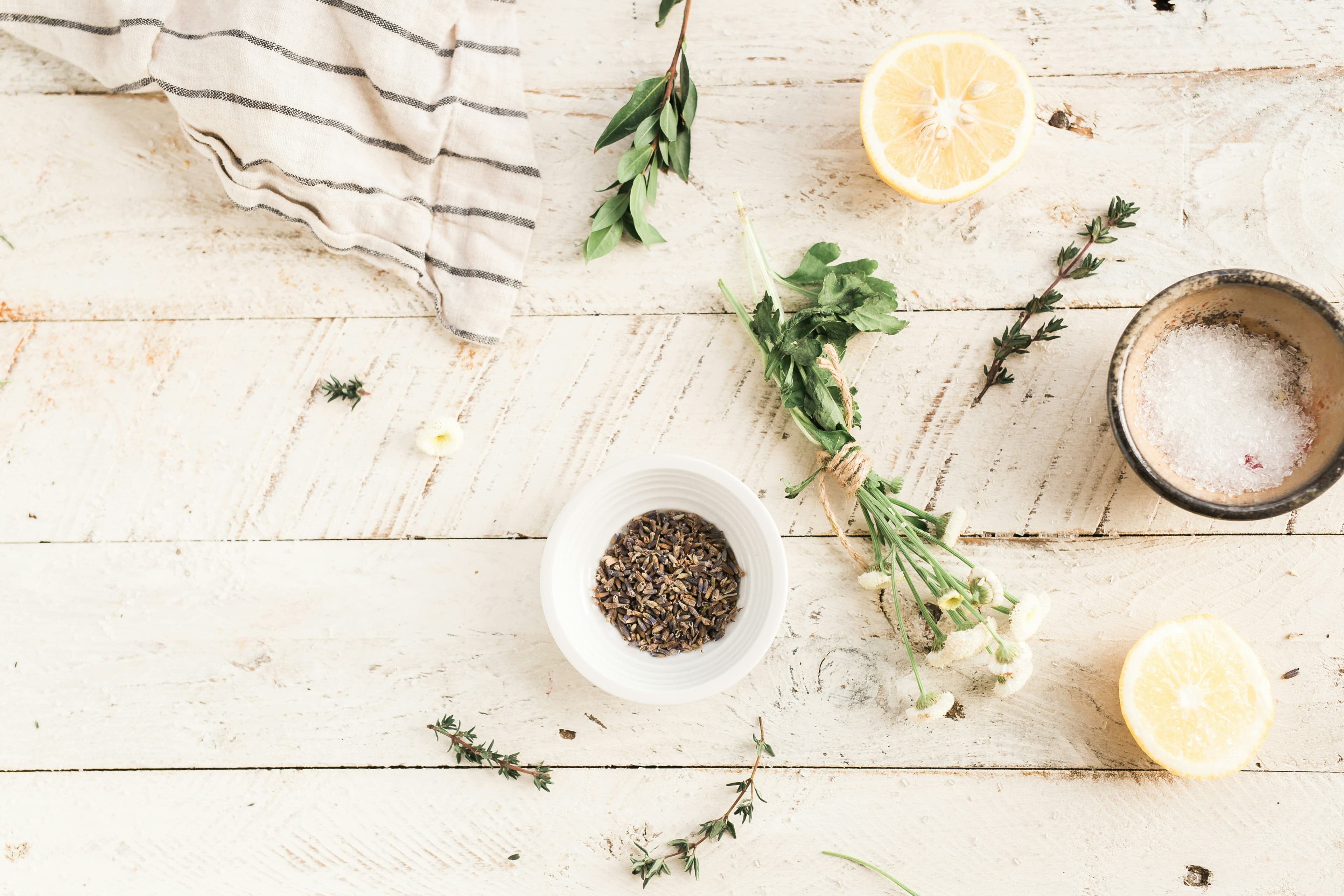 Lavender, lemon, herbs, and salt on a whitewashed table